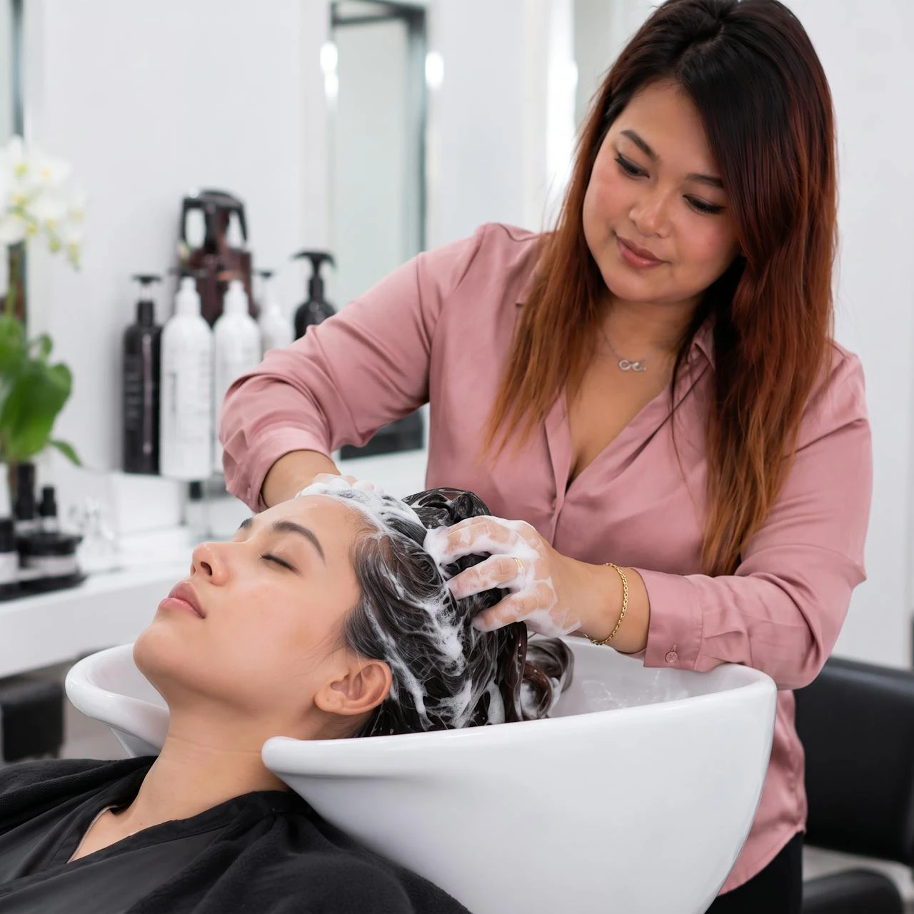 Sai washing a client's hair at the basin, Salon Rawai