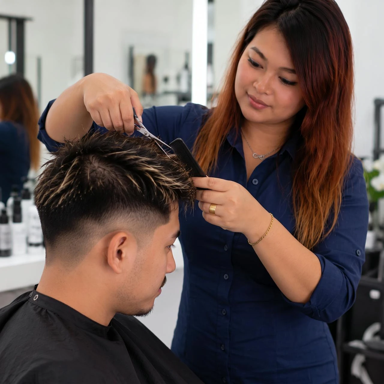 Sai cutting a man's textured fade with scissors, Salon Rawai